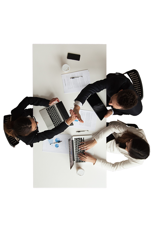 Team aus der Vogelperspektive bei einem Meeting mit Laptops und Dokumenten.